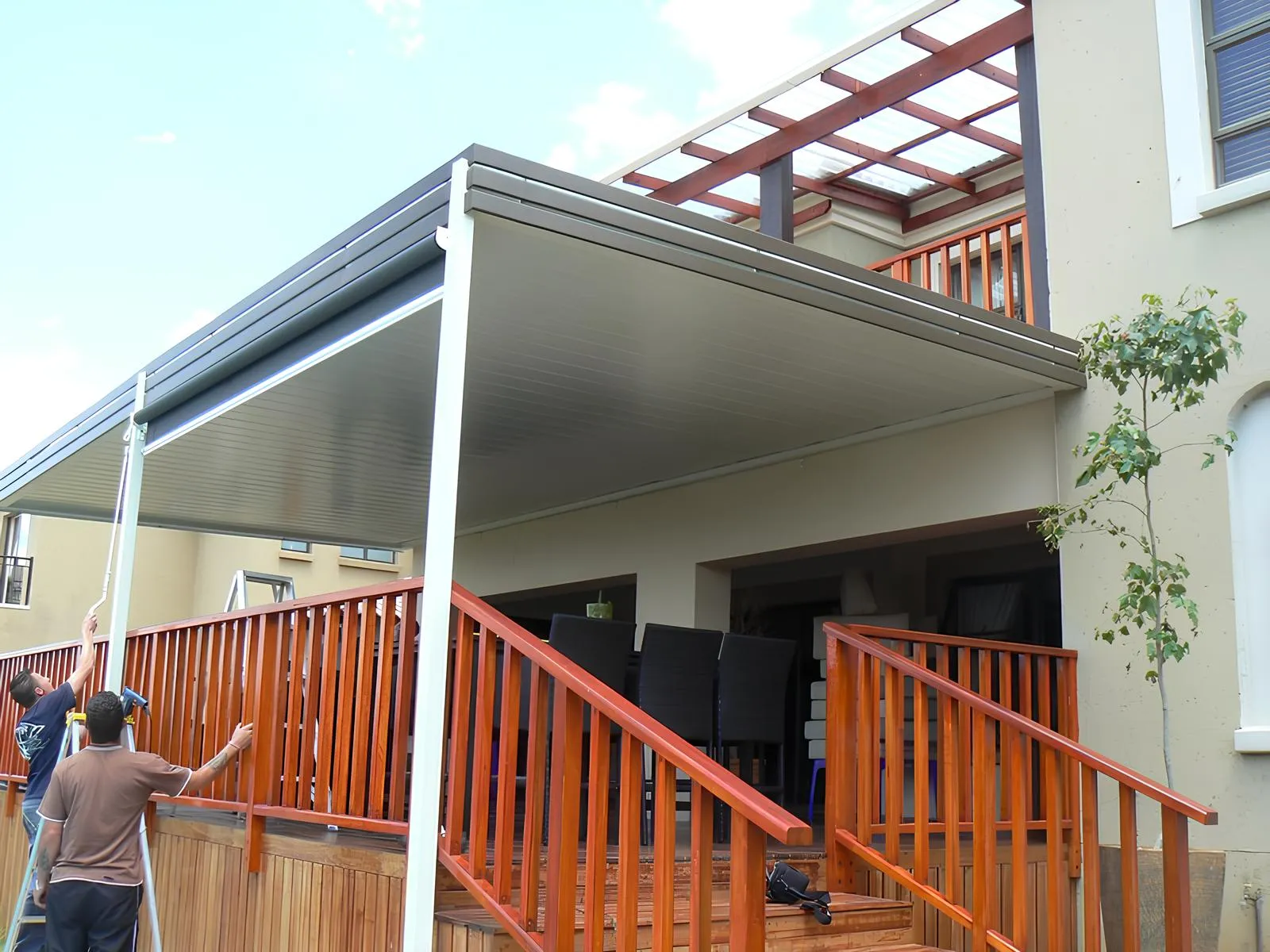 Flat white aluminium ceiling with a built-in gutter frame over an entertainment patio