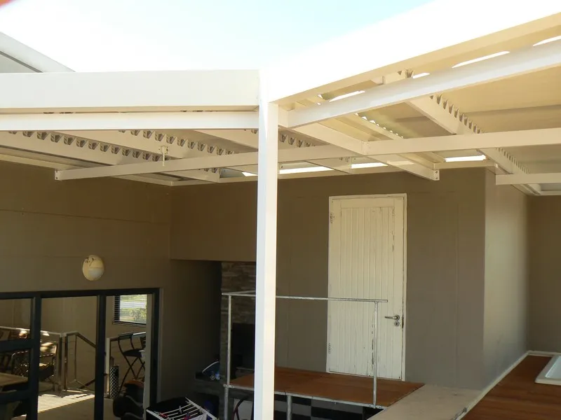 Arched polycarbonate canopy above a garden gate