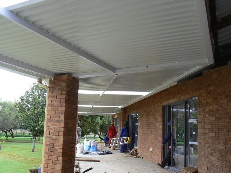 Sweeping polycarbonate awning across a patio corner