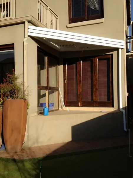 Custom-shaped polycarbonate awning on a modern home
