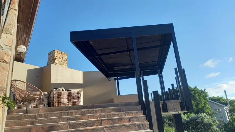 Cantilevered charcoal canopy over stone entrance steps
