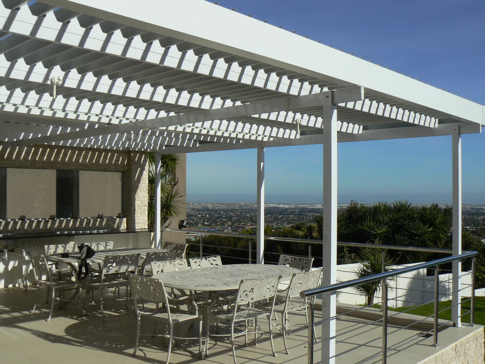 Adjustable louvre awning shading an indoor pool courtyard