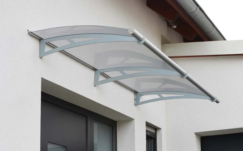 Curved coloured polycarbonate awning over a modern entrance