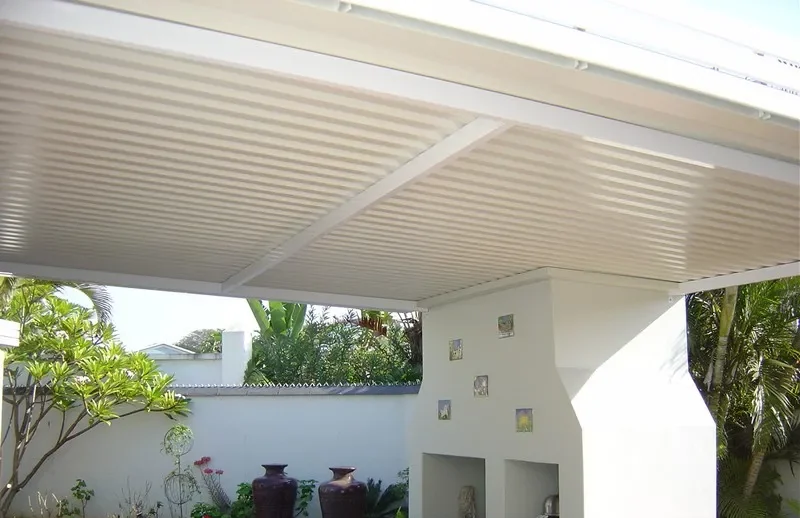 Cream fixed aluminium IBR cover over a poolside braai area